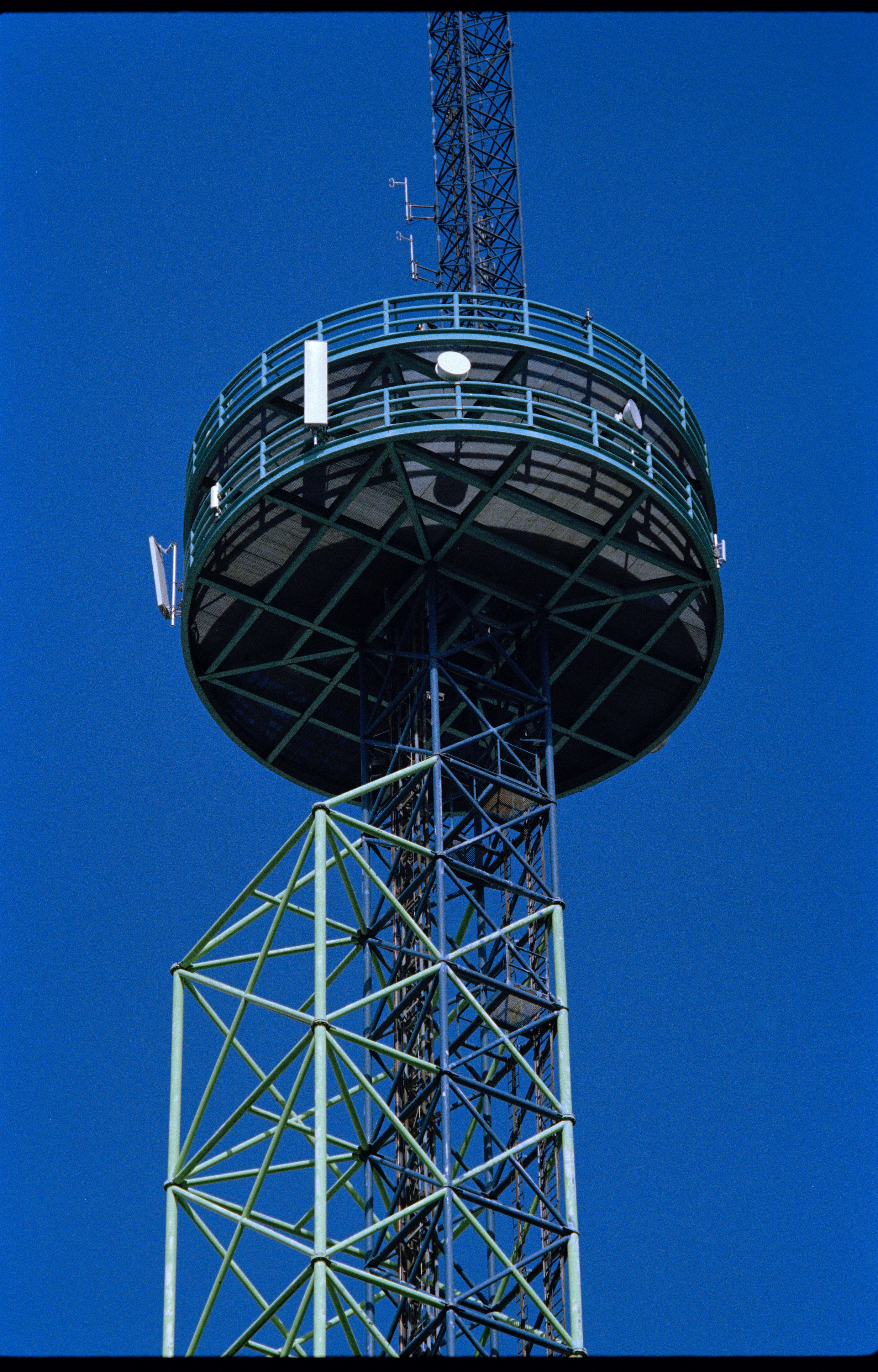 An old cellphone tower againast the bright blue sky.